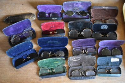 many pairs of glasses in a case on a table