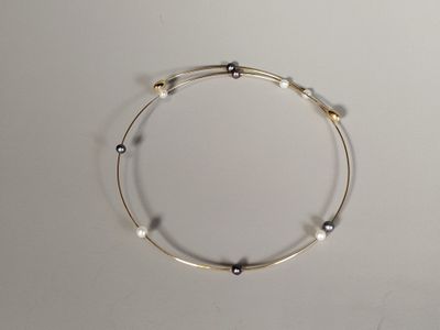 silver and black beaded bracelet on a white surface