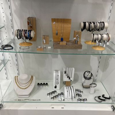 a glass display case with many different jewelry items on it