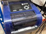 a blue machine that is sitting on top of a cardboard box