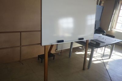 un tableau blanc posé sur un support au milieu d'une pièce