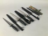 several knives are lined up in a row on a white surface