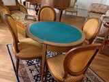 une table et des chaises dans un salon, avec un piano en arrière-plan