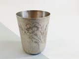 a silver cup with a design on it on a table