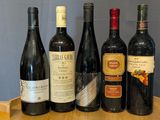 several bottles of wine are lined up on a wooden tray