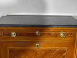 a small wooden chest of drawers with a black top