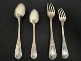 three silver spoons and two silver forks on a black surface