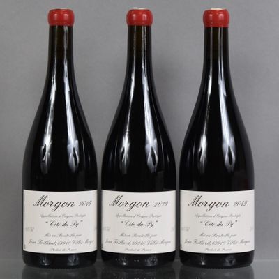 trois bouteilles de vin rouge sont alignées sur une table