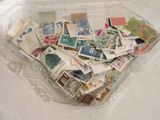 de nombreux timbres différents dans une boîte en plastique posée sur la table