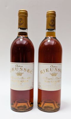 deux bouteilles de vin posées l'une à côté de l'autre sur une surface blanche