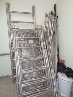 un tas d'échelles et un seau de déchets dans un garage
