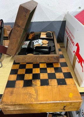 une table en bois sur laquelle se trouvent un échiquier et une boîte