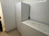 a man standing in a bathroom next to a bathtub