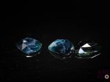 trois tourmalines bleues et vertes sur un fond noir