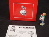 une petite figurine représentant un garçon avec un livre et une boîte rouge