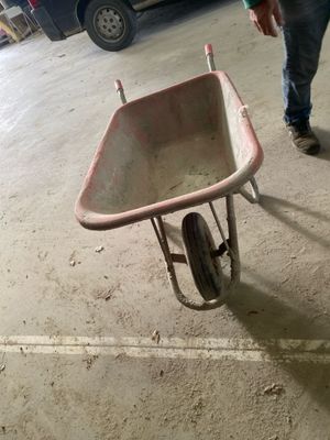 a man pushing a wheelbarrow in a parking garage
