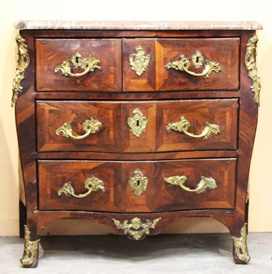 une commode en bois avec des poignées dorées et un plateau en marbre