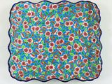 une assiette bleue et rouge ornée d'un motif floral