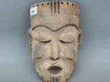 une image représentant un masque en bois sur fond gris