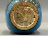 a close up of a blue vase with a gold lid