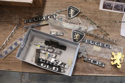 une boîte contenant des insignes de police posée sur une table, à côté d'une paire de ciseaux