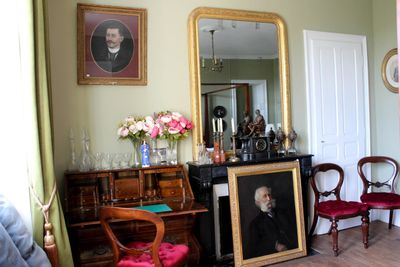 une photo d'un salon avec le portrait d'un homme accroché au mur