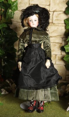 a doll that is wearing a black dress and red shoes