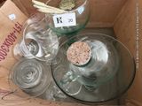 a box full of empty wine glasses and a cork stopper
