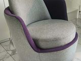 une chaise grise et violette posée sur un sol carrelé blanc