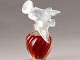 a glass bottle with a bird on top of it