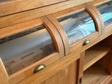 a wooden cabinet with a glass door on top of it