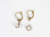 two pairs of gold hoop earrings with pearls on them