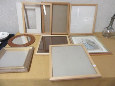 four frames on a table with a mirror and a lamp