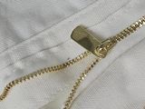 a close up of a zipper on a white shirt