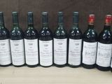several bottles of wine are lined up in a row on a table