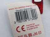 a label on the back of a green and white teddy bear