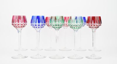 six wine glasses are lined up in a row on a white surface