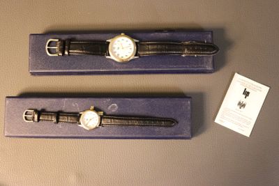two watches that are on display in a purple box