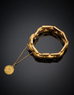un bracelet en or auquel est suspendue une pièce de monnaie