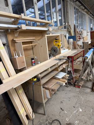 Dans un atelier, plusieurs morceaux de bois sont empilés les uns sur les autres