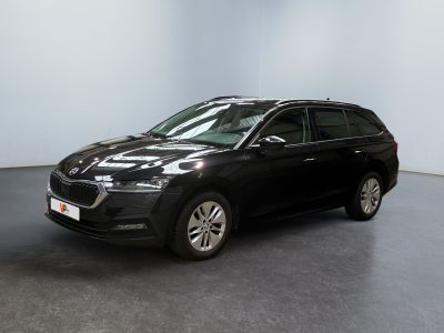 Une voiture noire est garée dans une pièce aux murs blancs