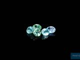 a couple of green and blue gems sitting on top of a black surface