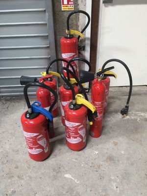 Plusieurs extincteurs sont alignés à côté d'une porte de garage