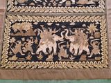 two rugs with elephants on them on a green surface