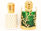 two bottles of perfume sitting next to each other on a white surface