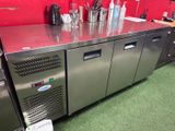un comptoir en acier inoxydable sur lequel sont posées plusieurs bouteilles