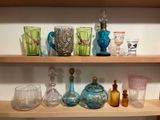 de nombreux vases en verre de différentes couleurs posés sur une étagère