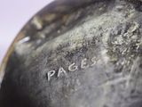 a close up of a metal object with a name on it