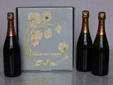 three bottles of champagne sitting next to each other on a table