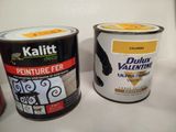 two cans of paint sitting on a counter next to each other